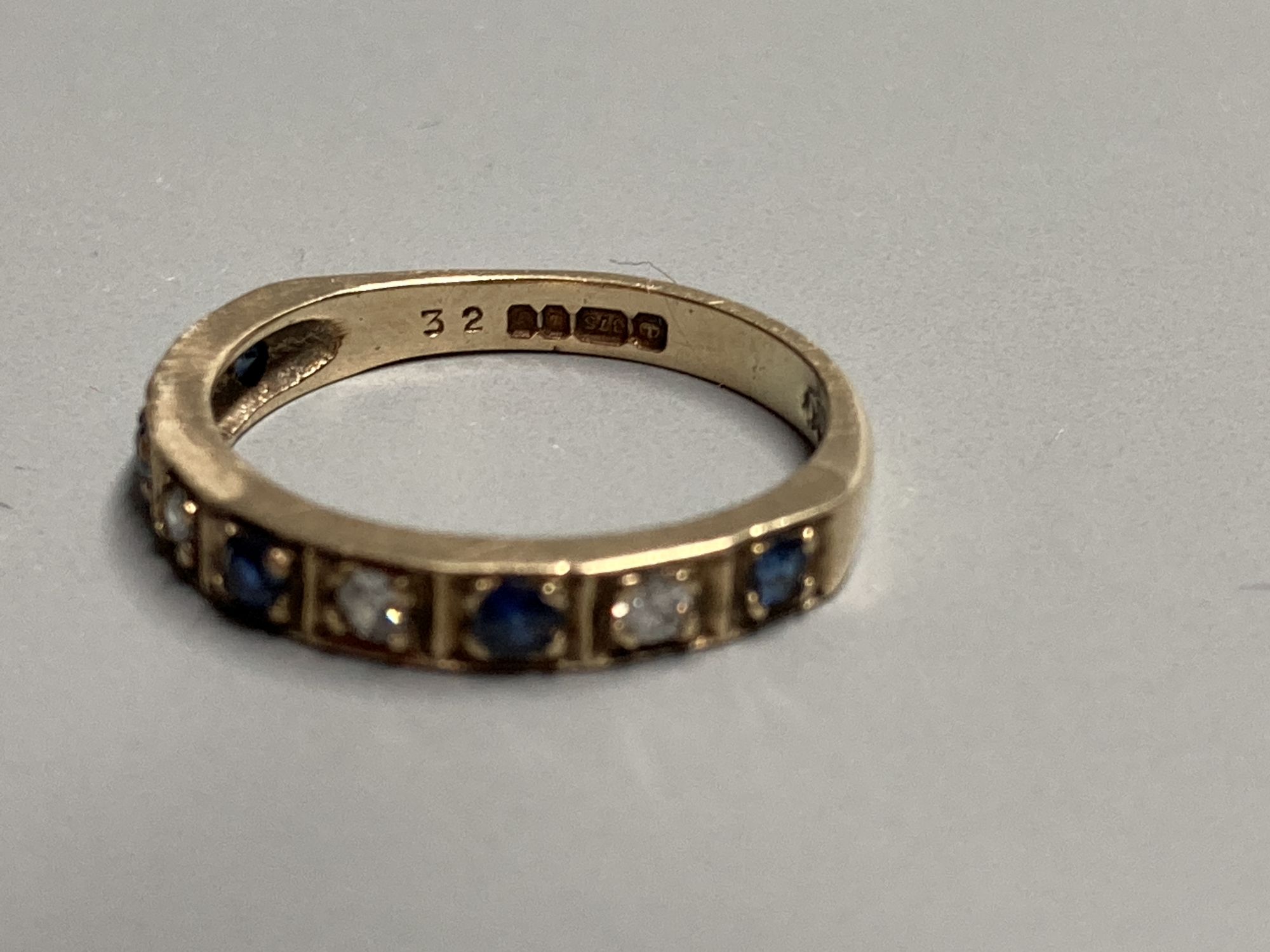 A modern 9ct gold, sapphire and diamond set nine stone half hoop ring, size L, gross 2.3 grams.
